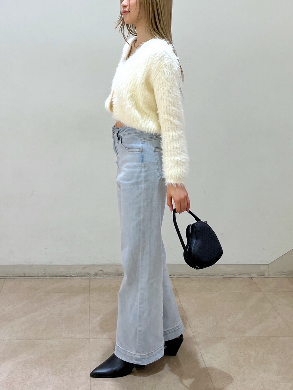 ホワイト系のカーディガン/ボレロ、ブルー系のデニムパンツ、ブラック系のショルダーバッグを着用したレディースの春コーディネートの2枚目の写真