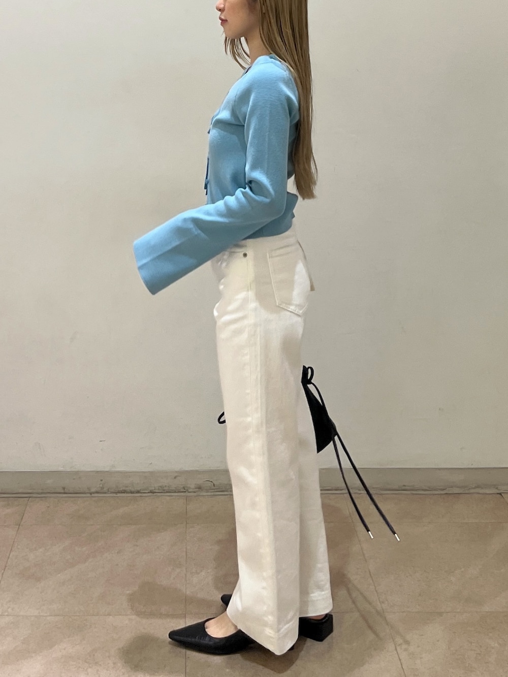 ホワイト系のデニムパンツ、ブラック系のショルダーバッグ、ブラック系のパンプスを着用したレディースの春コーディネートの2枚目の写真