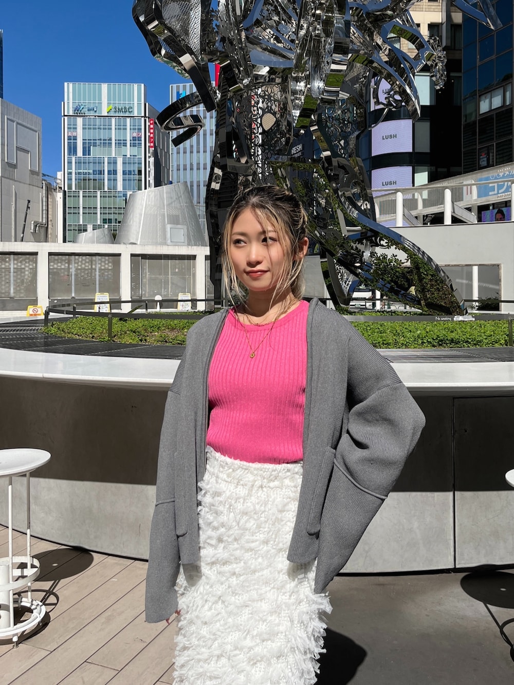 ブラック系のブーツ、ホワイト系のスカート、ピンク系のニット/セーターを着用したレディースの秋コーディネートの4枚目の写真