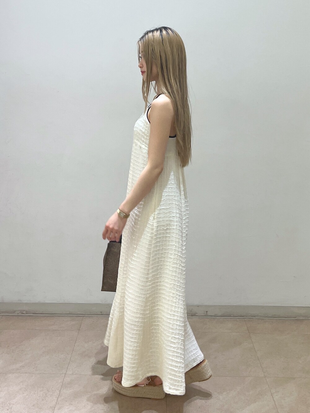 ベージュ系のテーラードジャケット、ブラウン系のショルダーバッグ、ホワイト系のワンピースを着用したレディースの春コーディネートの8枚目の写真