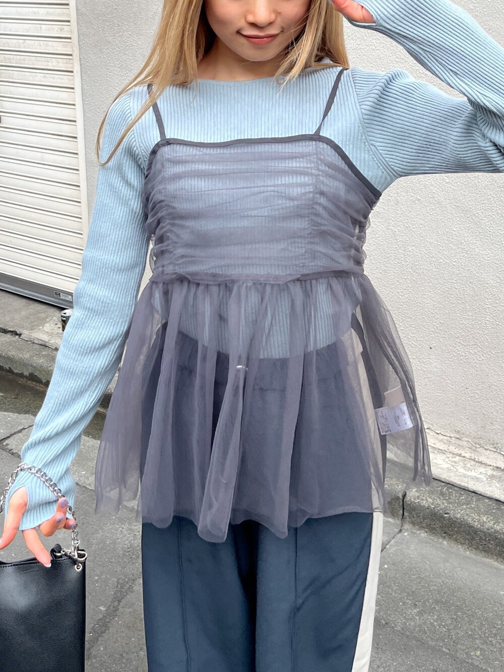 ブルー系のニット/セーター、ブラック系のショルダーバッグ、グレー系のシャツ/ブラウスを着用したレディースの冬コーディネートの6枚目の写真