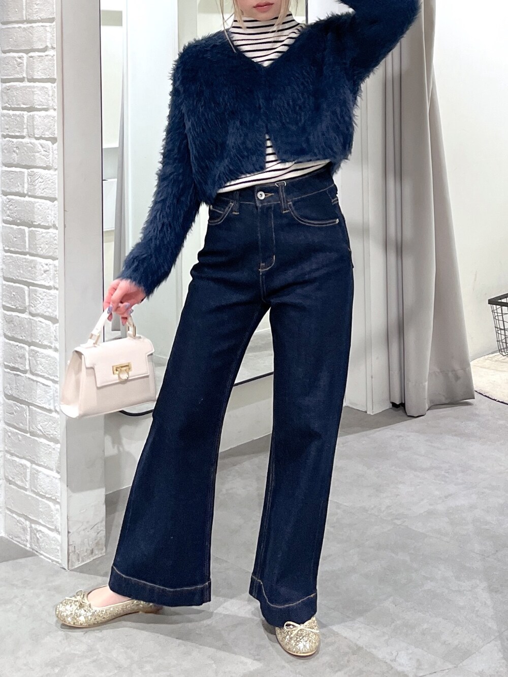 ホワイト系のニット/セーター、ブルー系のカーディガン/ボレロ、ホワイト系のショルダーバッグを着用したレディースの冬コーディネートの6枚目の写真