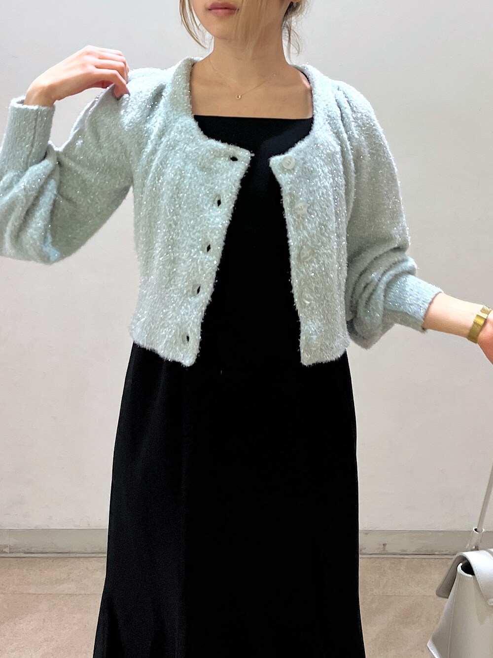 グリーン系のカーディガン/ボレロ、ホワイト系のショルダーバッグ、ブラック系のワンピースを着用したレディースの冬コーディネートの10枚目の写真