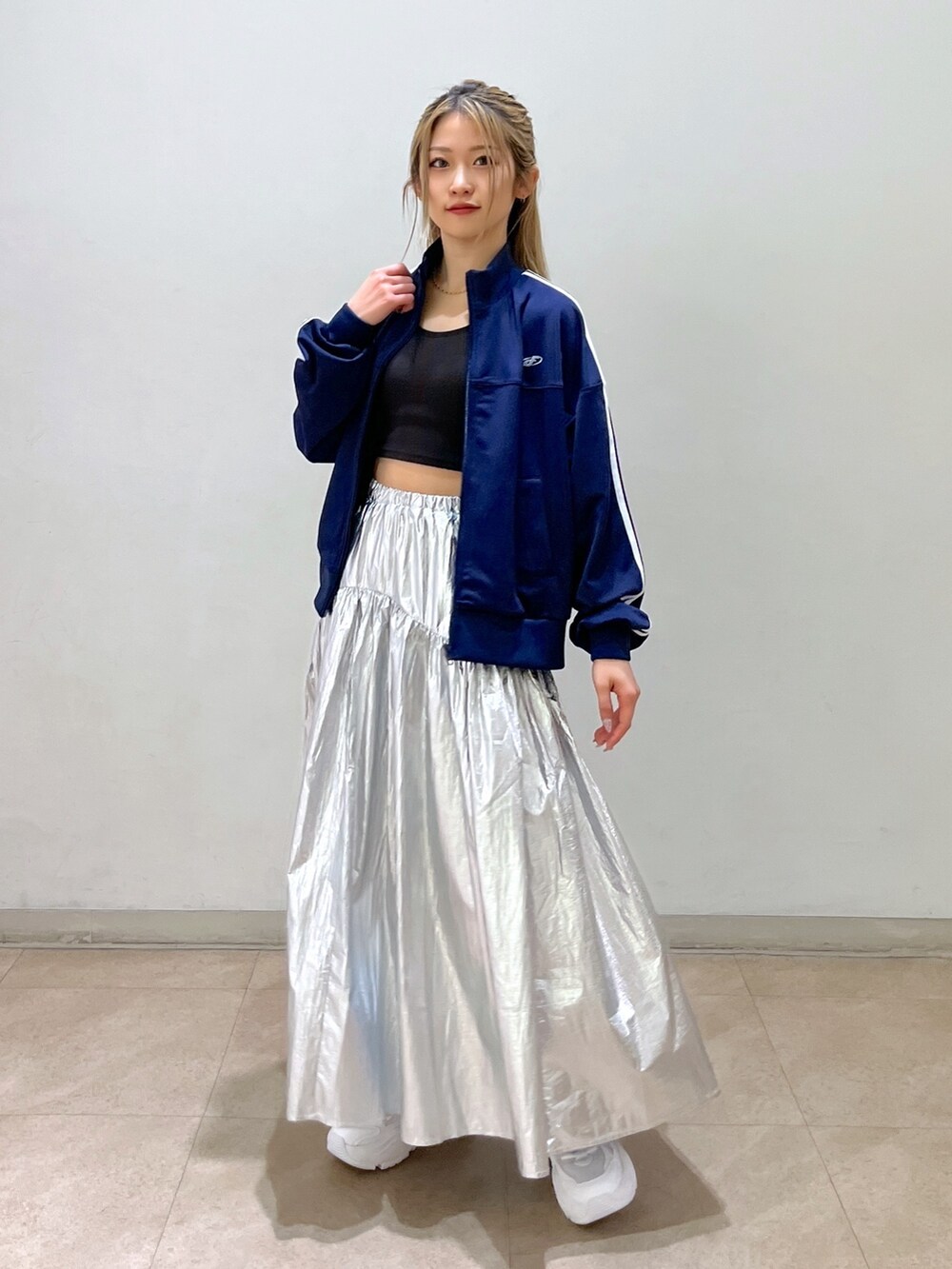 ブルー系のブルゾン、ブラック系のショルダーバッグ、シルバー系のスカートを着用したレディースの春コーディネートの4枚目の写真