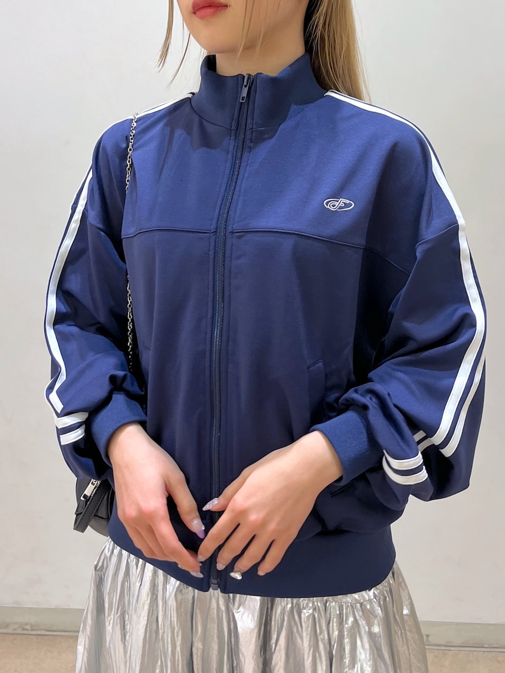 ブルー系のブルゾン、ブラック系のショルダーバッグ、シルバー系のスカートを着用したレディースの春コーディネートの9枚目の写真