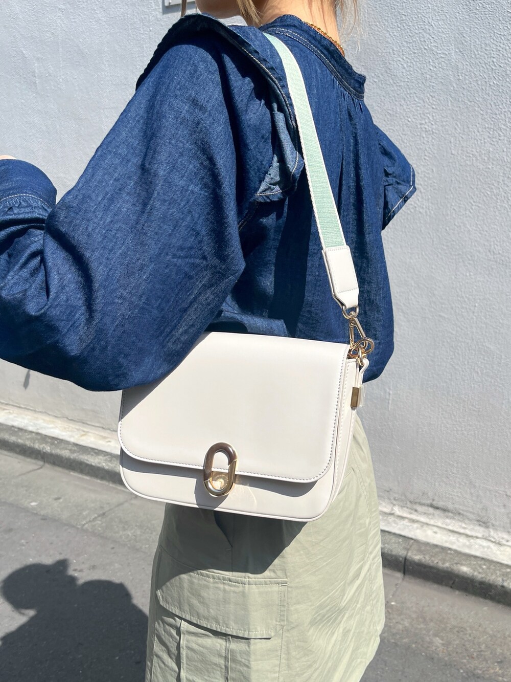 グリーン系のスカート、ホワイト系のショルダーバッグ、ブルー系のシャツ/ブラウスを着用したレディースの春コーディネートの9枚目の写真