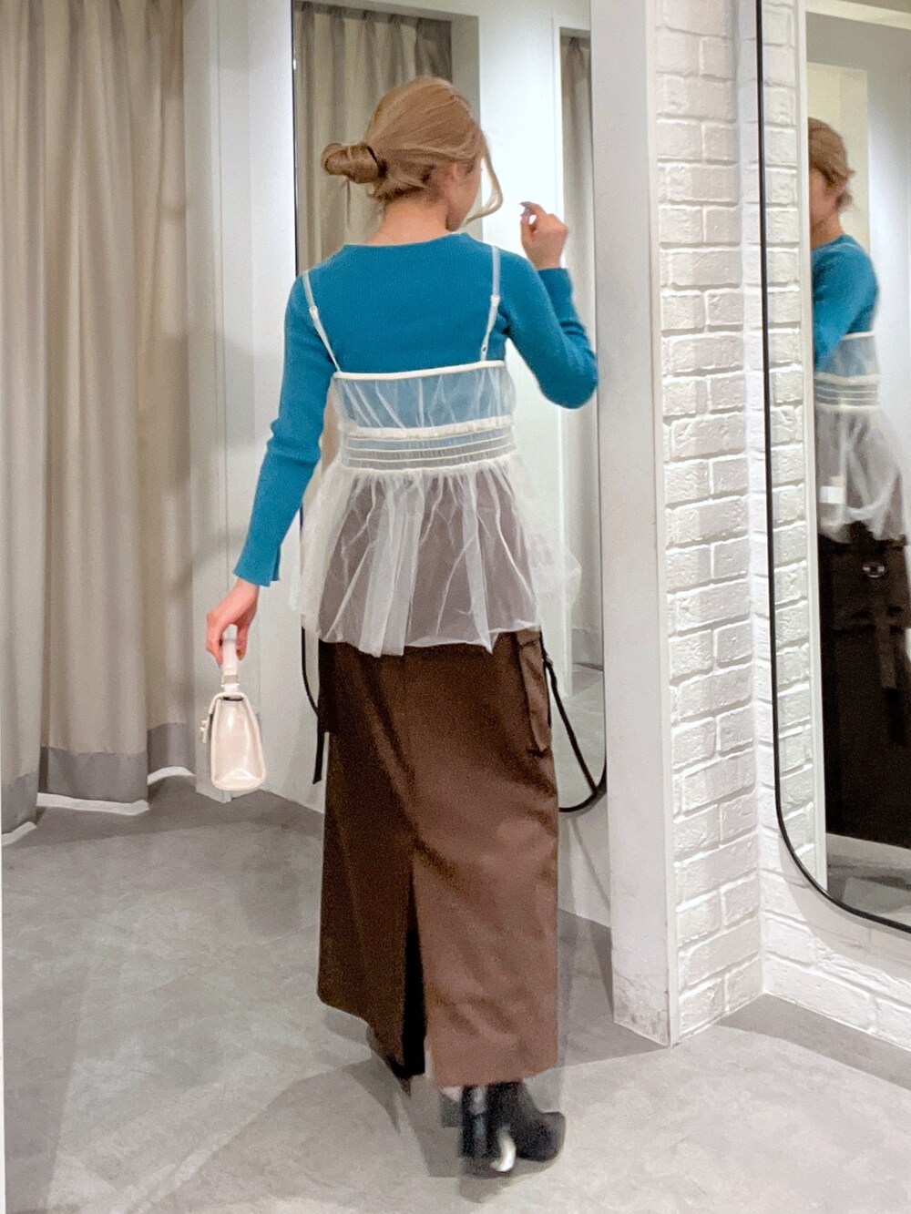 ブラウン系のスカート、ホワイト系のシャツ/ブラウス、ホワイト系のショルダーバッグを着用したレディースの冬コーディネートの3枚目の写真