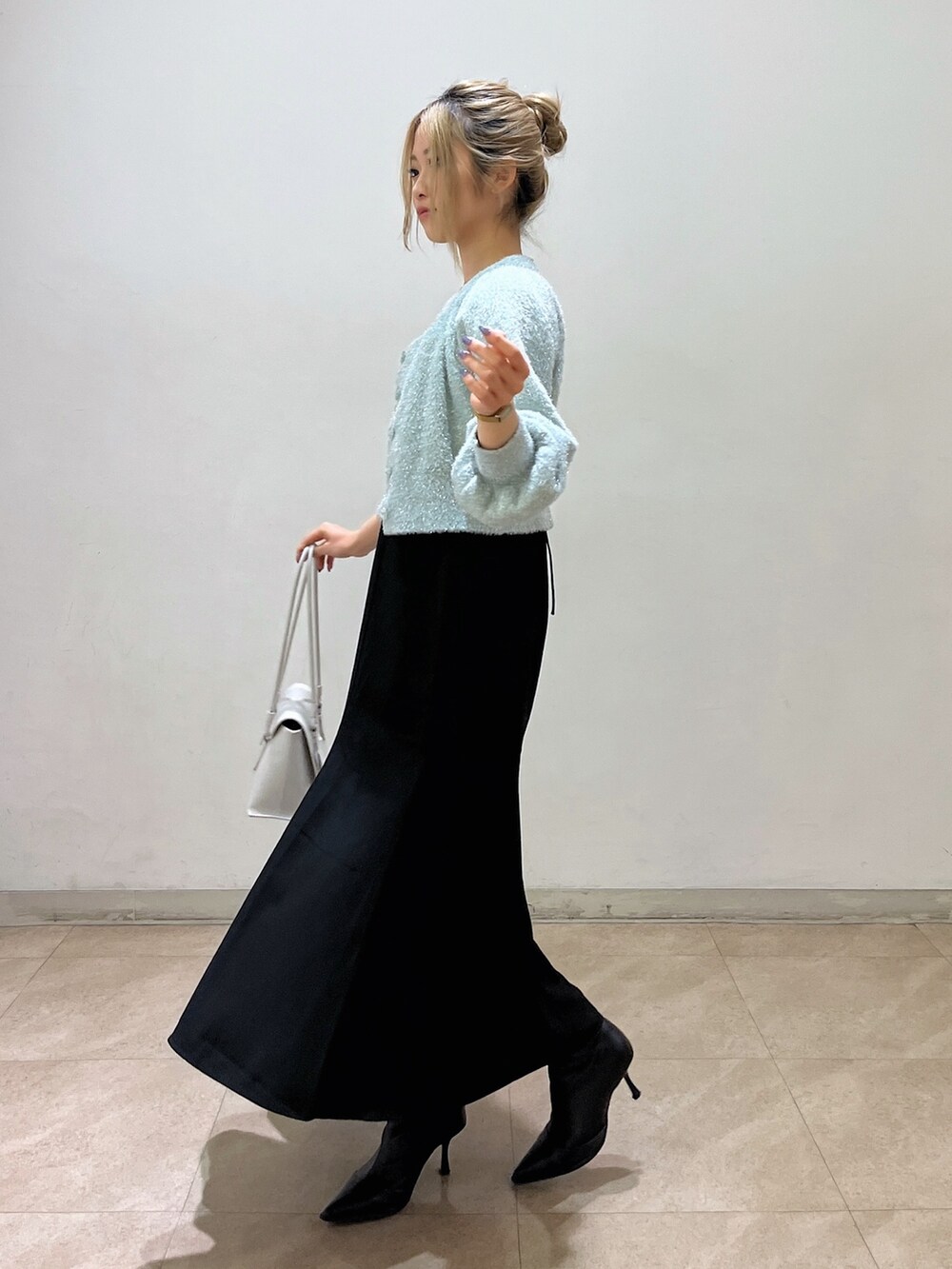 グリーン系のカーディガン/ボレロ、ホワイト系のショルダーバッグ、ブラック系のワンピースを着用したレディースの冬コーディネートの3枚目の写真