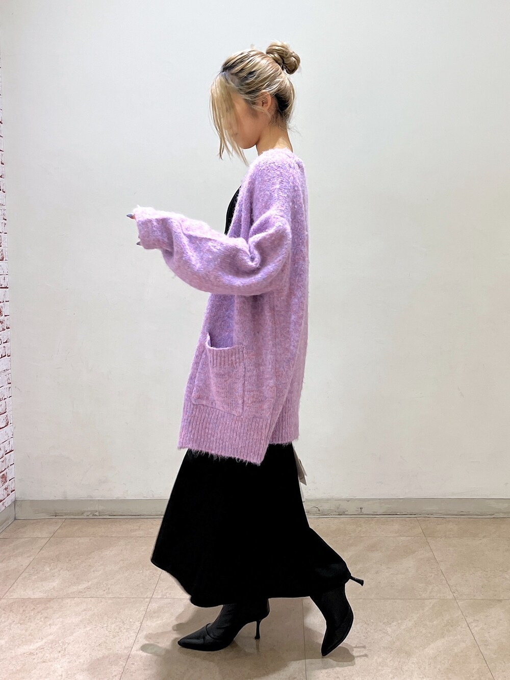 ブラック系のワンピース、パープル系のカーディガン/ボレロ、ホワイト系のショルダーバッグを着用したレディースの冬コーディネートの3枚目の写真