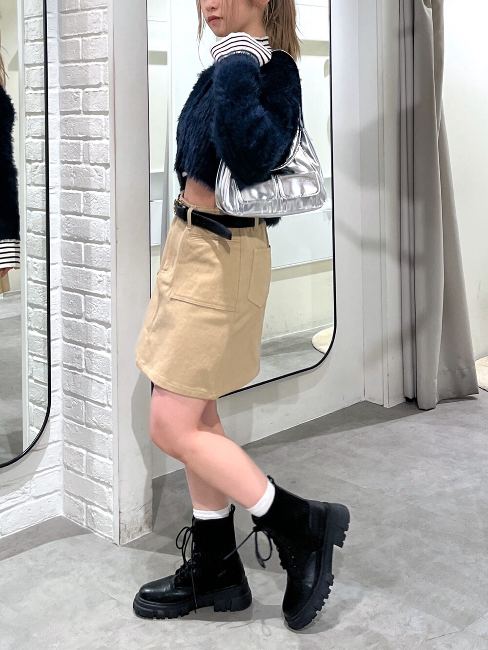 ブルー系のカーディガン/ボレロ、ホワイト系のニット/セーター、ブラック系のブーツを着用したレディースの冬コーディネートの2枚目の写真