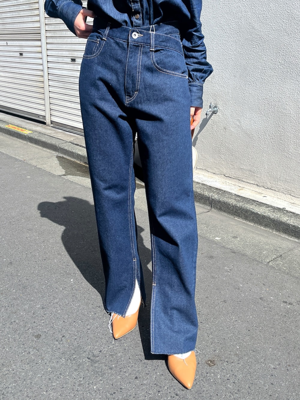 ブルー系のシャツ/ブラウス、ブルー系のデニムパンツ、ブラウン系のショルダーバッグを着用したレディースの春コーディネートの8枚目の写真