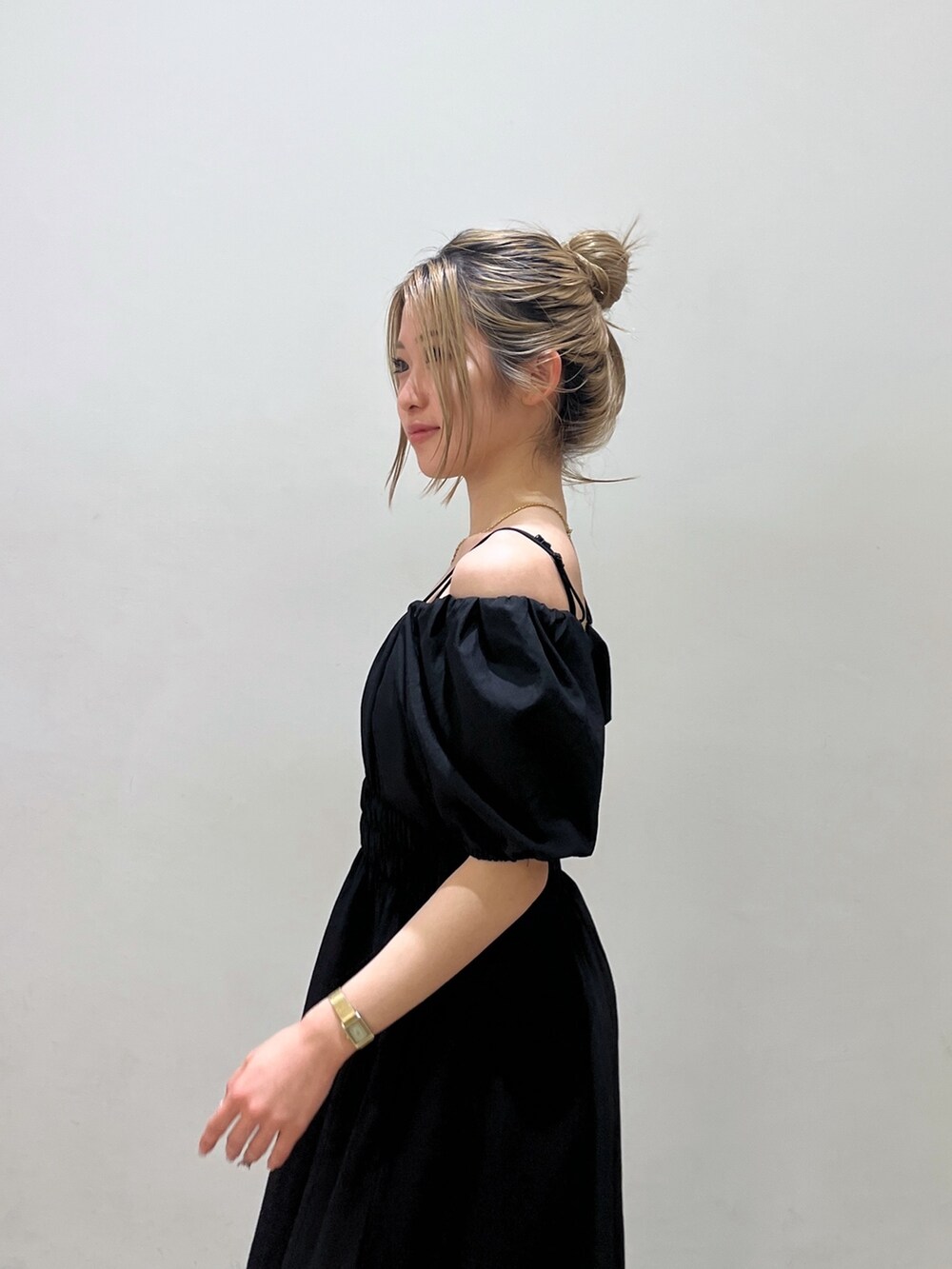 ブラック系のワンピース、シルバー系のハンドバッグ、ホワイト系のサンダルを着用したレディースの春コーディネートの5枚目の写真