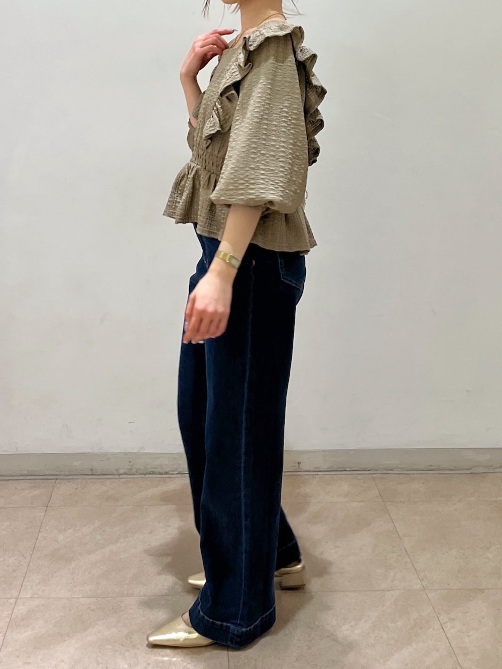 ブラウン系のシャツ/ブラウス、ブルー系のデニムパンツ、ゴールド系のパンプスを着用したレディースの春コーディネートの3枚目の写真