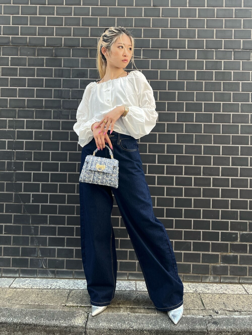 ブルー系のデニムパンツ、ホワイト系のシャツ/ブラウス、ブルー系のショルダーバッグを着用したレディースの秋コーディネートの3枚目の写真