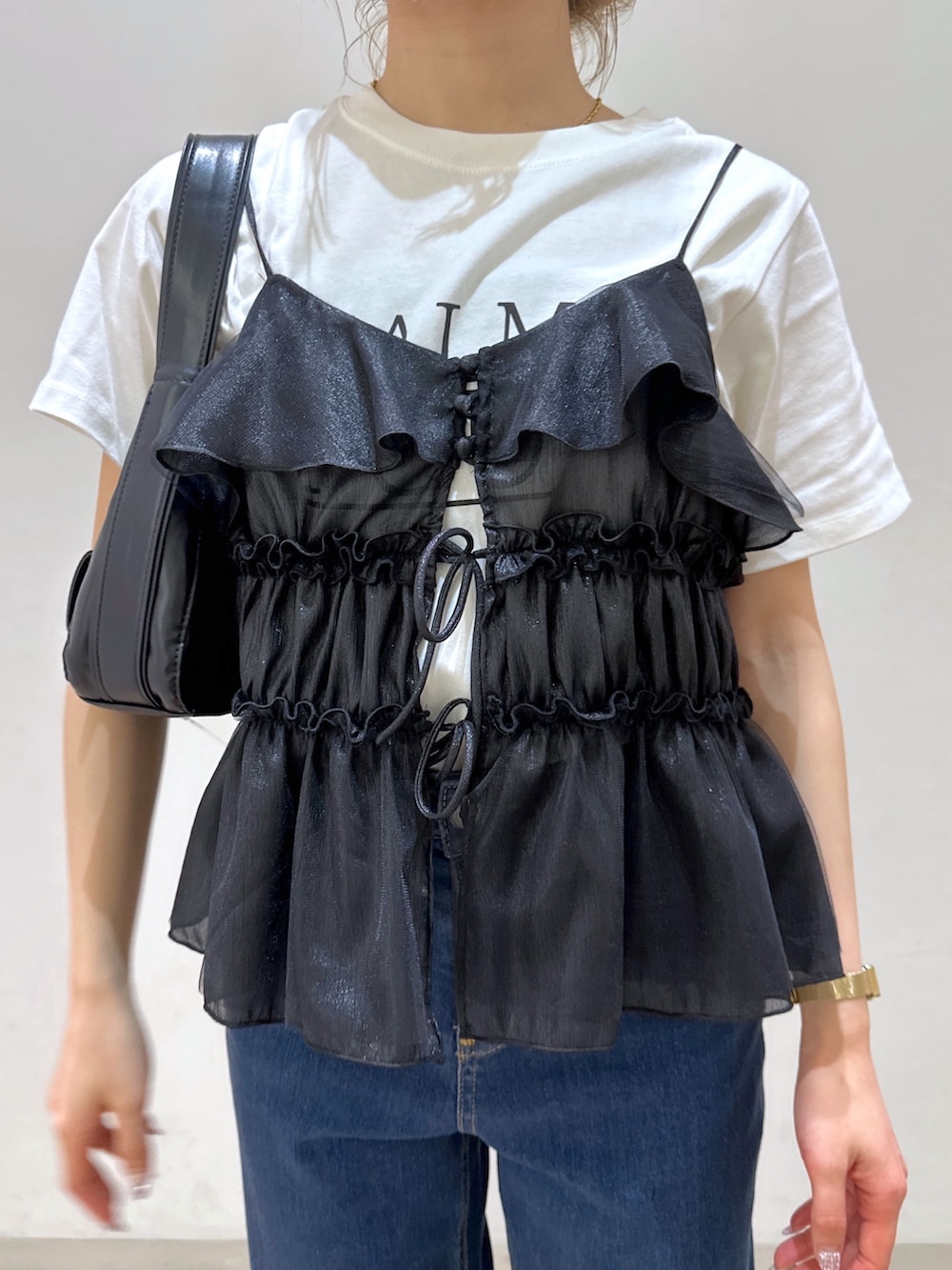 ブラック系のショルダーバッグ、ブラック系のシャツ/ブラウス、ホワイト系のTシャツ/カットソーを着用したレディースの春コーディネートの10枚目の写真