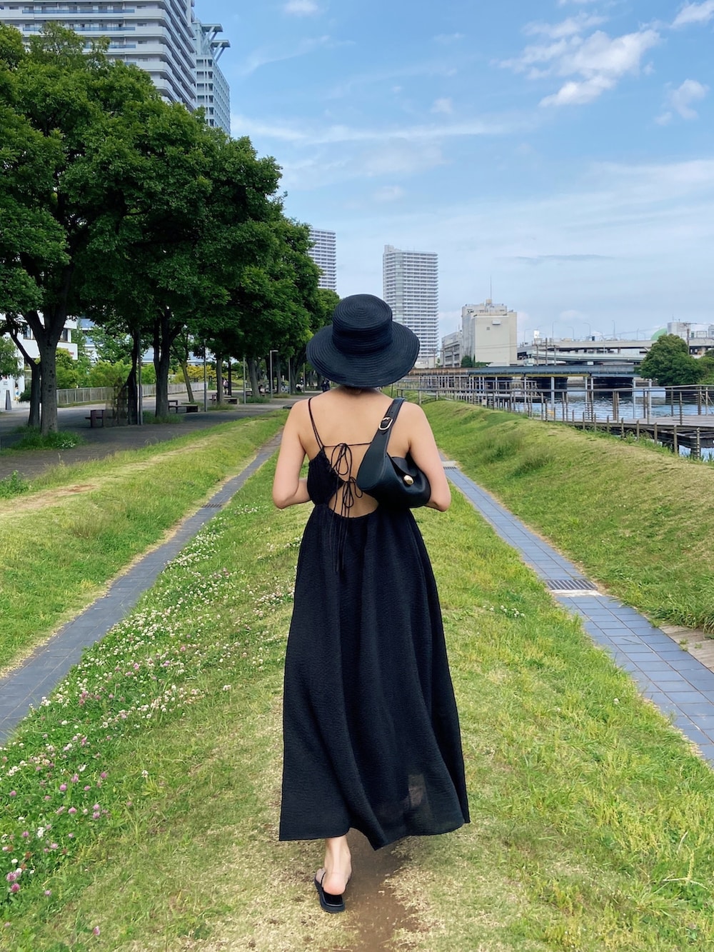 ブラック系のワンピース、ブラック系のサンダル、ブラック系のハットを着用したレディースの春コーディネートの2枚目の写真
