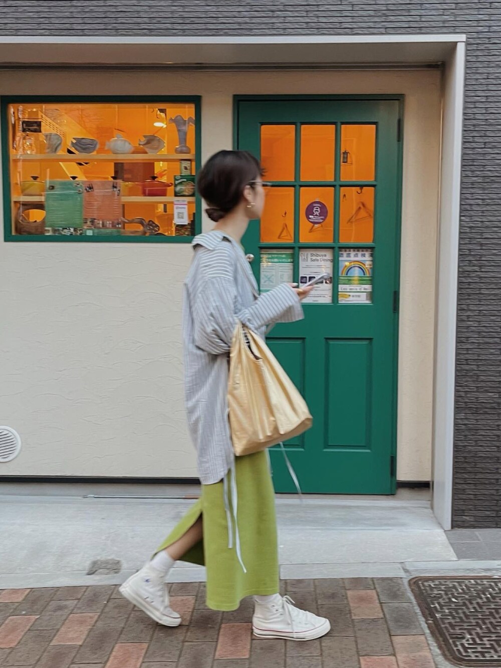 グリーン系のワンピース、ゴールド系のエコバッグ/サブバッグ、ブルー系のシャツ/ブラウスを着用したレディースの春コーディネートの4枚目の写真