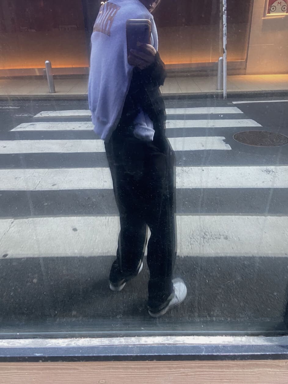 ブラック系のスラックス、グレー系のスウェット、ブルー系のキャップを着用したレディースの冬コーディネートの4枚目の写真