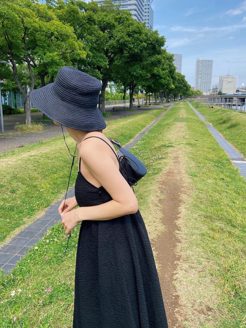ブラック系のワンピース、ブラック系のサンダル、ブラック系のハットを着用したレディースの春コーディネートの7枚目の写真