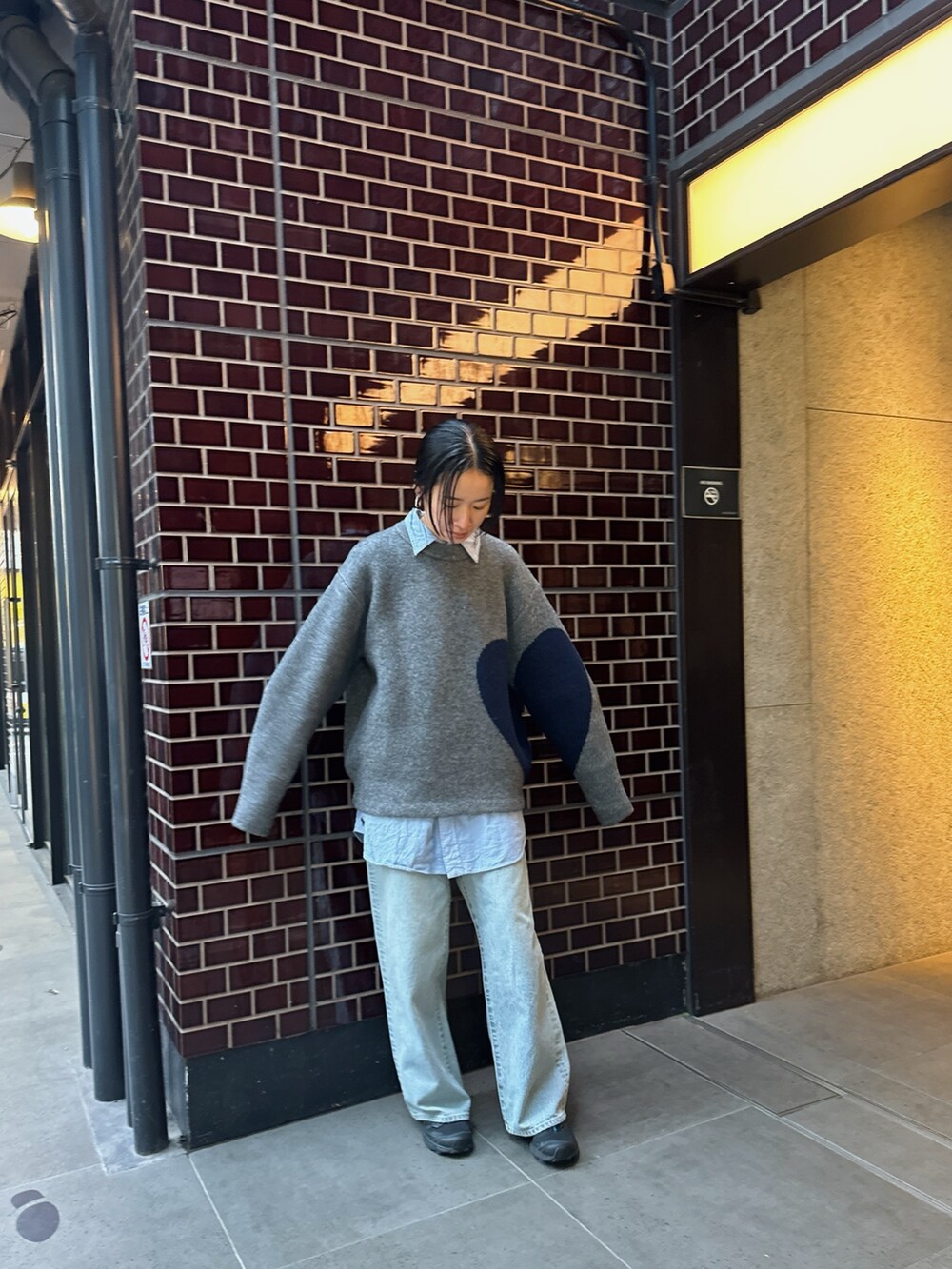 ブルー系のデニムパンツ、ブラック系のスニーカーを着用したレディースの春コーディネートの2枚目の写真