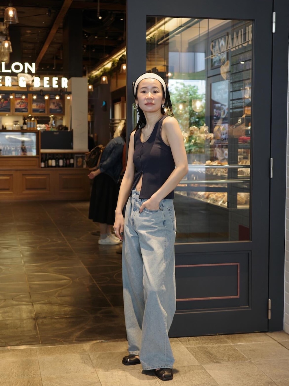 ブルー系のタンクトップ、ブルー系のデニムパンツ、ブラック系のサンダルを着用したレディースの春コーディネートの4枚目の写真