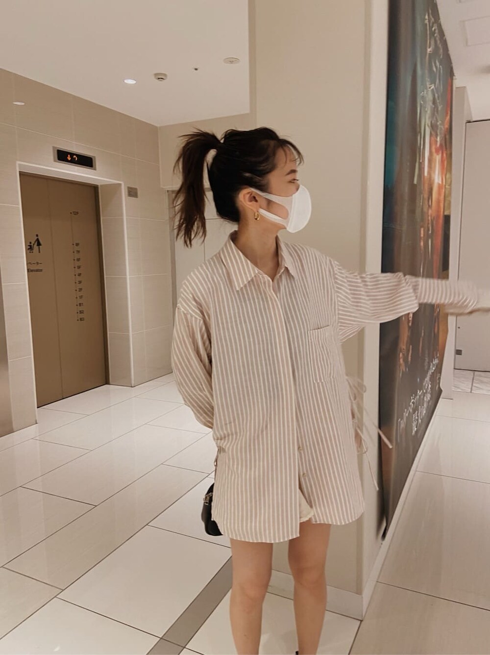 ピンク系のシャツ/ブラウス、ブラック系のハンドバッグを着用したレディースの春コーディネートの4枚目の写真