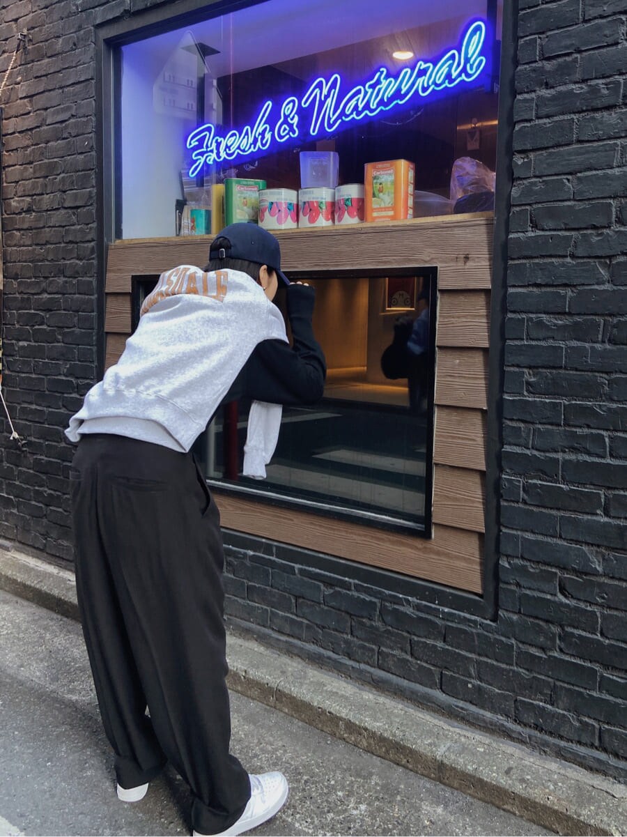 ブラック系のスラックス、グレー系のスウェット、ブルー系のキャップを着用したレディースの冬コーディネートの3枚目の写真