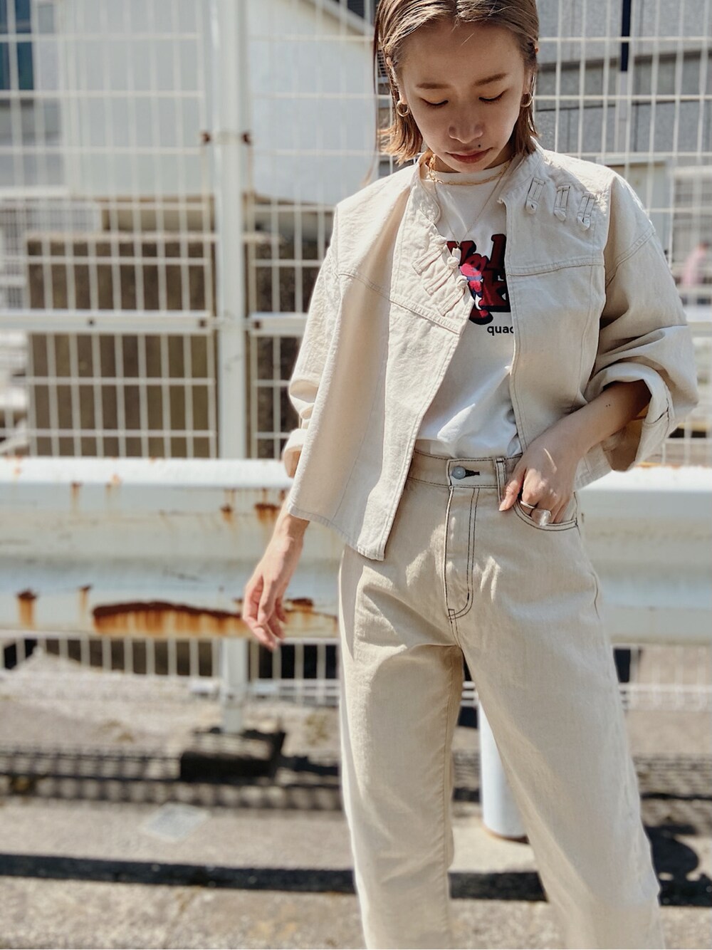 ホワイト系のデニムパンツ、ホワイト系のブルゾン、ホワイト系のTシャツ/カットソーを着用したレディースの春コーディネートの3枚目の写真