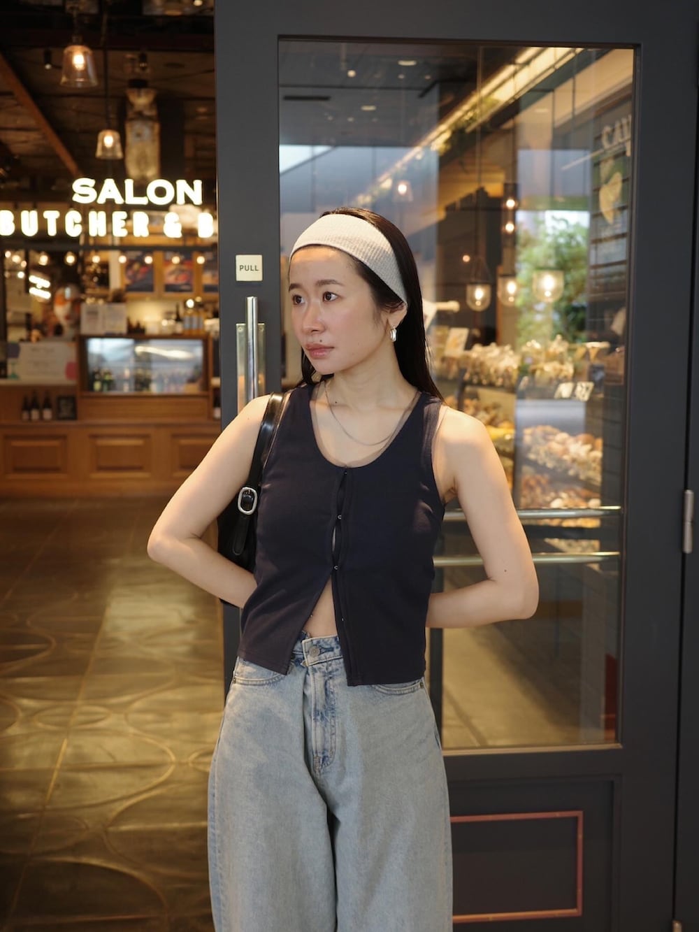 ブルー系のタンクトップ、ブルー系のデニムパンツ、ブラック系のサンダルを着用したレディースの春コーディネートの5枚目の写真