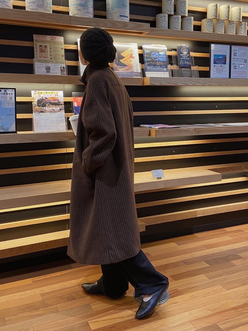 レッド系のニット/セーター、ブラウン系のその他アウター、ブラック系のデニムパンツを着用したレディースの秋コーディネートの2枚目の写真