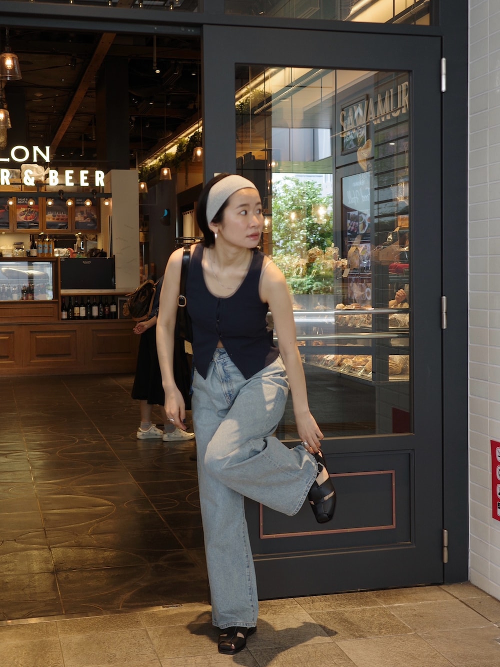 ブルー系のタンクトップ、ブルー系のデニムパンツ、ブラック系のサンダルを着用したレディースの春コーディネートの2枚目の写真