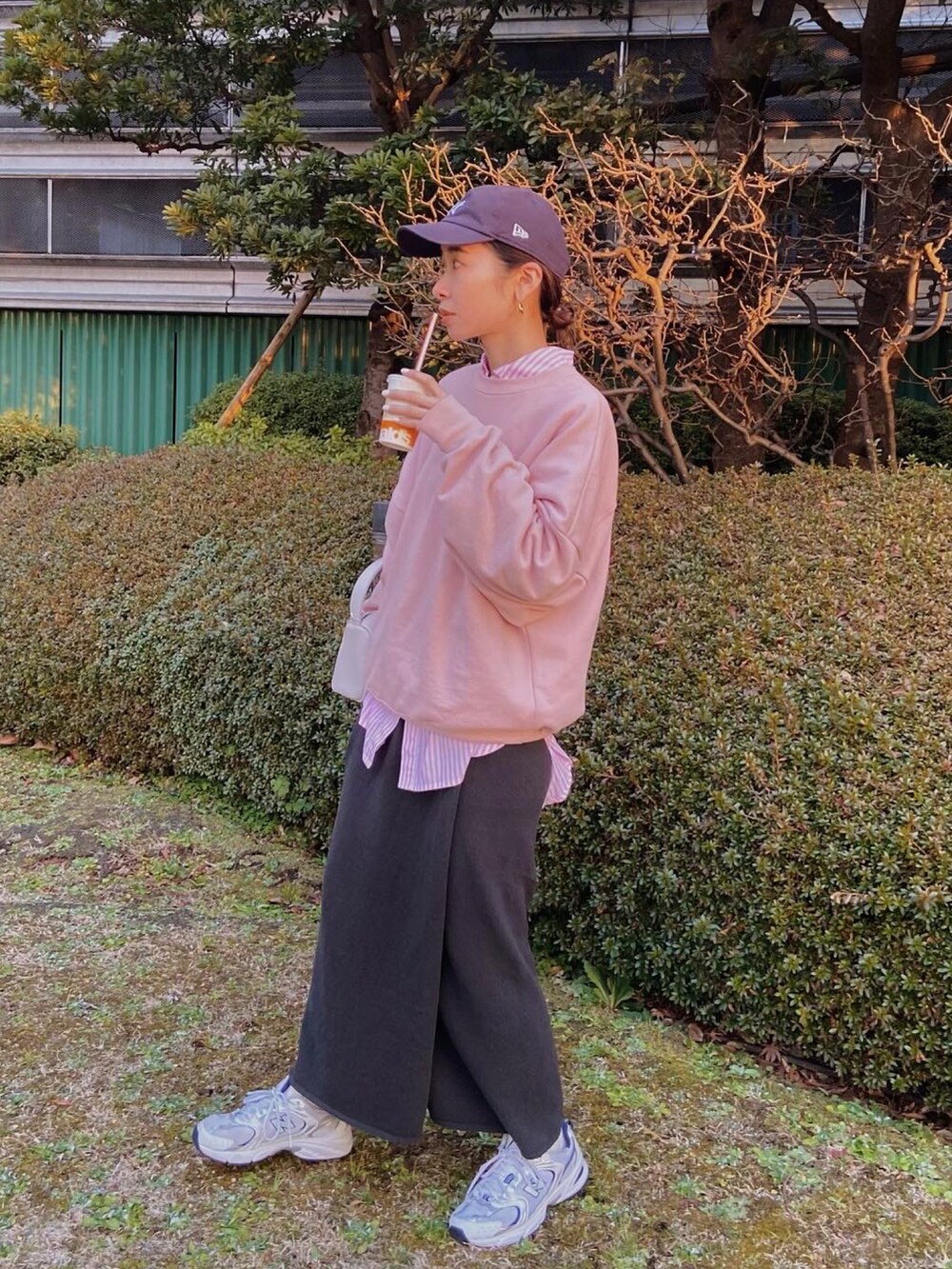 ピンク系のスウェット、ピンク系のハンドバッグ、グレー系のスカートを着用したレディースの冬コーディネートの3枚目の写真