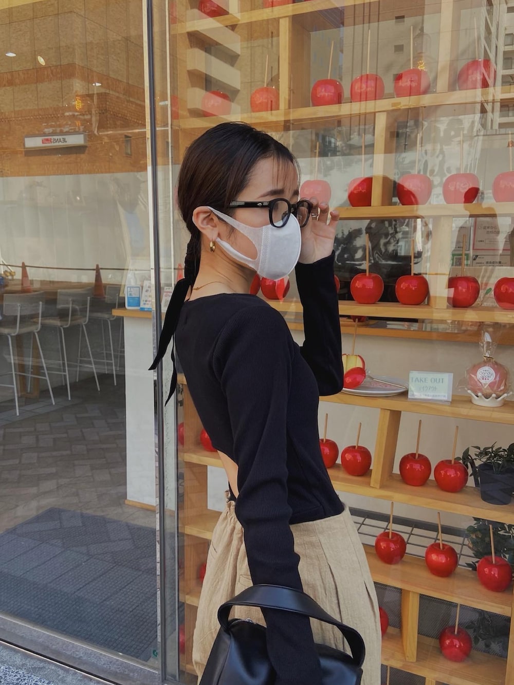 ブラック系のTシャツ/カットソー、ブラック系のハンドバッグ、ベージュ系のその他パンツを着用したレディースの春コーディネートの2枚目の写真