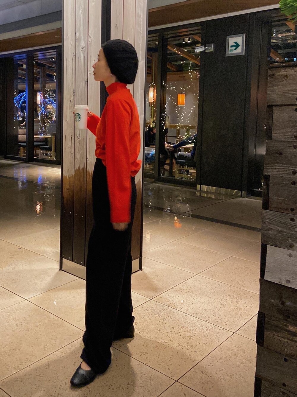 レッド系のニット/セーター、ブラウン系のその他アウター、ブラック系のデニムパンツを着用したレディースの秋コーディネートの4枚目の写真