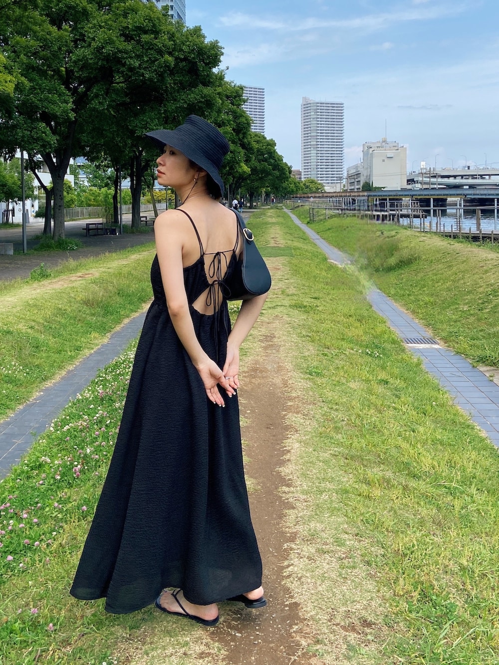 ブラック系のワンピース、ブラック系のサンダル、ブラック系のハットを着用したレディースの春コーディネートの3枚目の写真