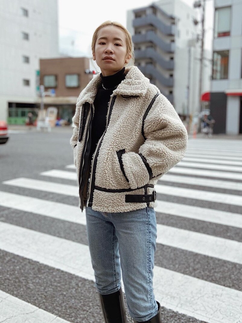 ベージュ系のムートンコートを着用したレディースの冬コーディネートの3枚目の写真