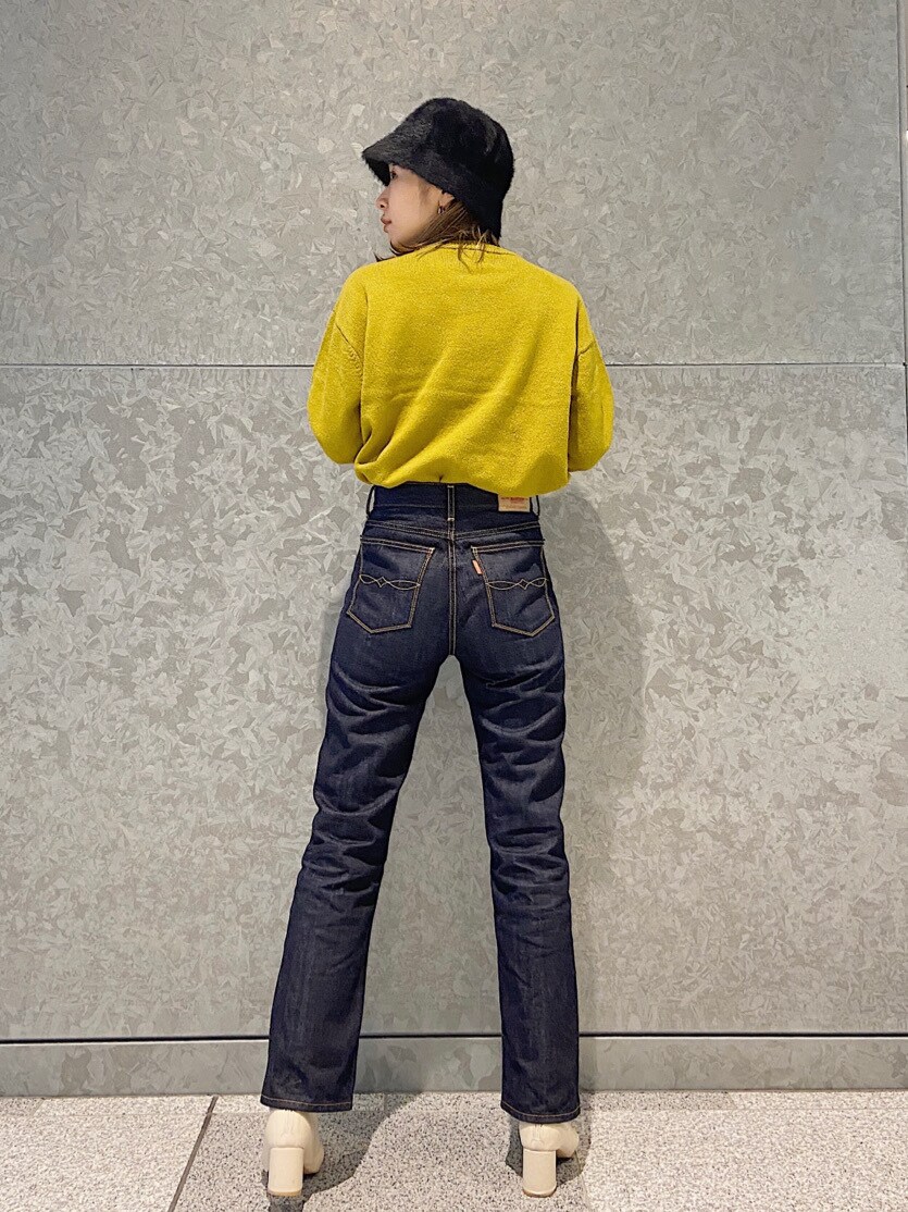 ブルー系のデニムパンツ、グリーン系のニット/セーターを着用したレディースの秋コーディネートの2枚目の写真