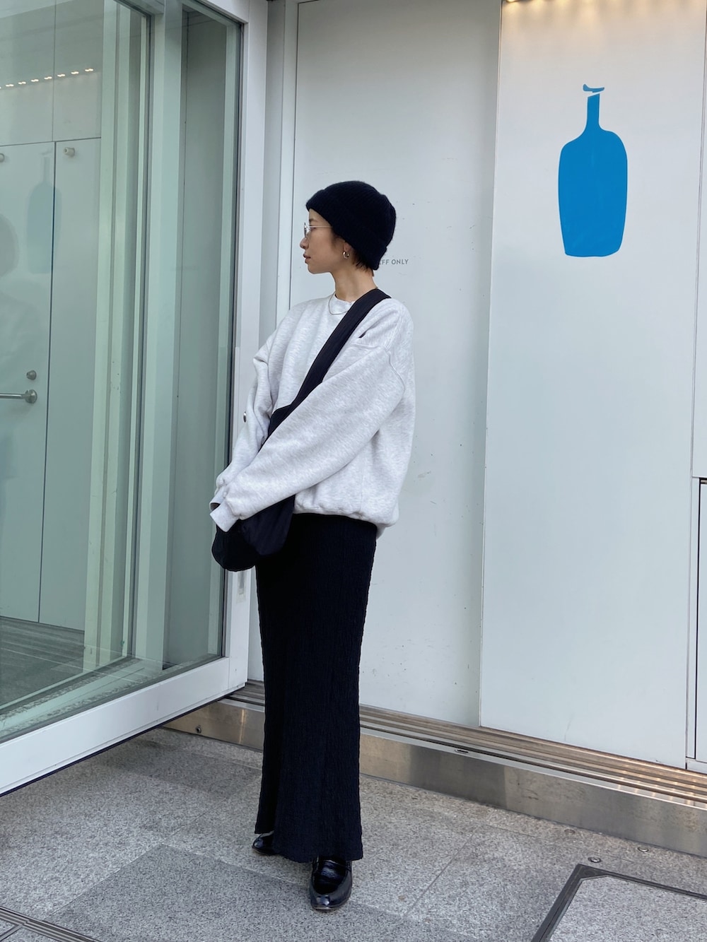 ブラック系のスカート、ブラック系のショルダーバッグ、ブラック系のニットキャップ/ビーニーを着用したレディースの冬コーディネートの4枚目の写真