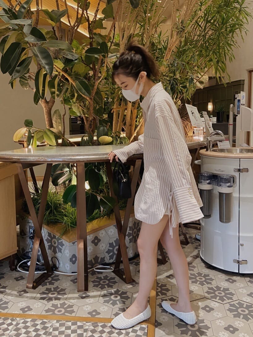 ピンク系のシャツ/ブラウス、ブラック系のハンドバッグを着用したレディースの春コーディネートの2枚目の写真