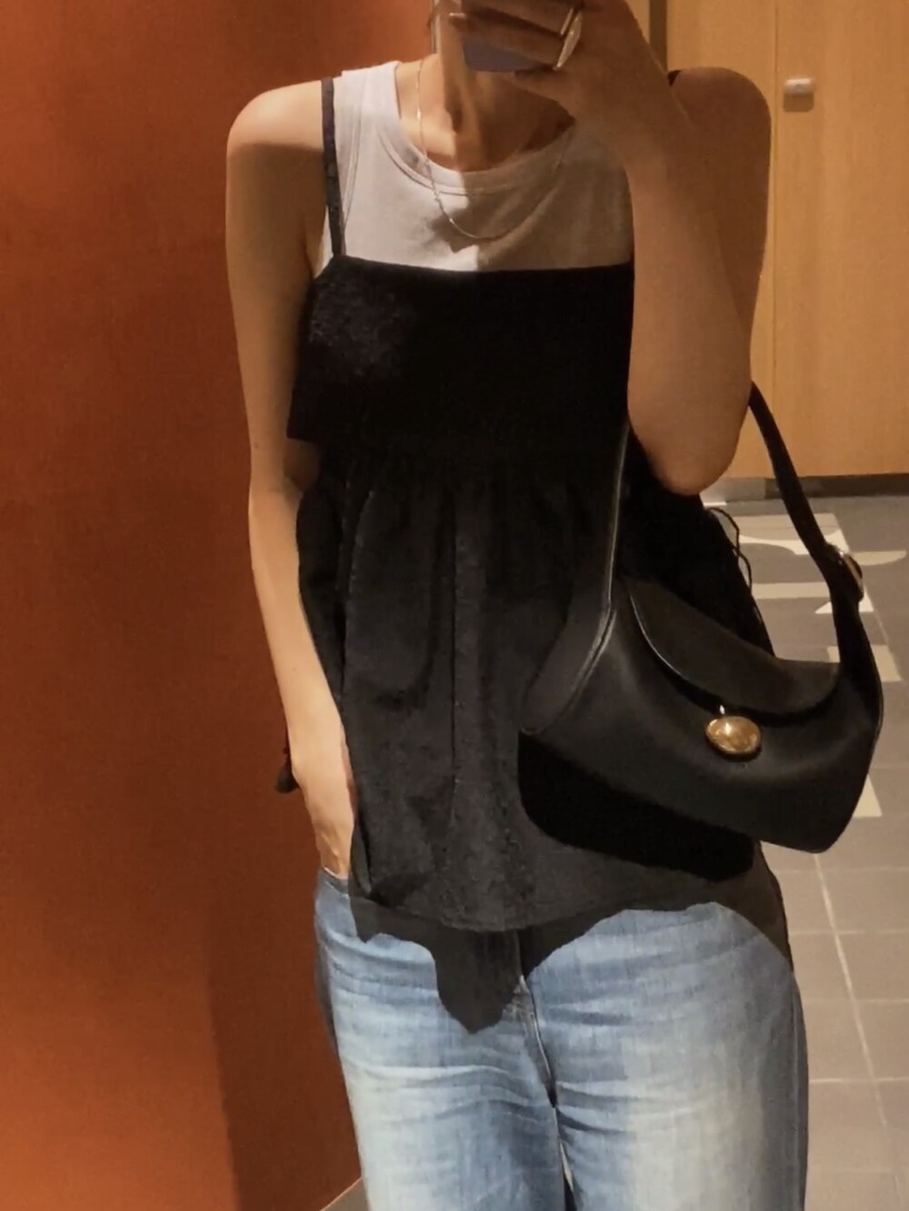 ブラック系のシャツ/ブラウス、ブルー系のデニムパンツ、ブラック系のサンダルを着用したレディースの春コーディネートの5枚目の写真