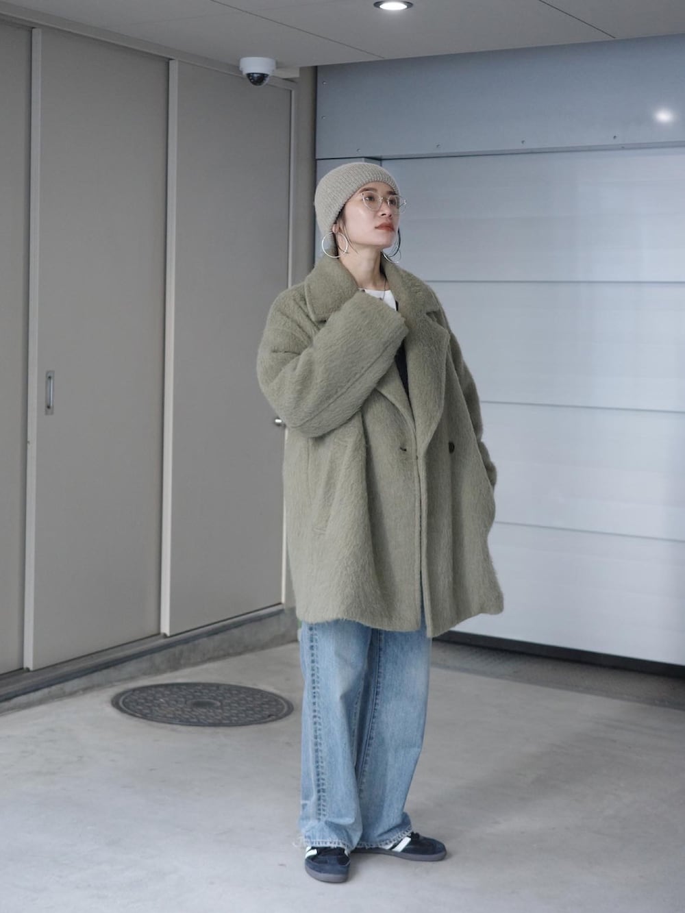 ブルー系のデニムパンツ、グレー系のニット/セーター、ホワイト系のTシャツ/カットソーを着用したレディースの冬コーディネートの3枚目の写真