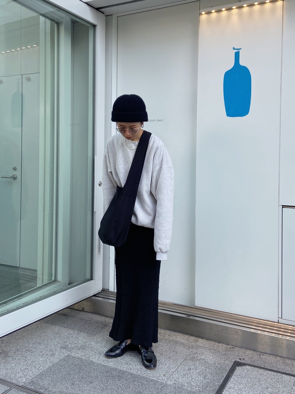 ブラック系のスカート、ブラック系のショルダーバッグ、ブラック系のニットキャップ/ビーニーを着用したレディースの冬コーディネートの3枚目の写真