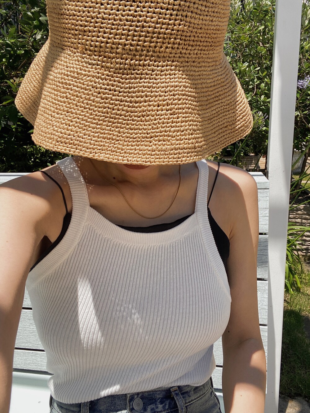 ホワイト系のタンクトップ、ブラック系のキャミソール、ブルー系のデニムパンツを着用したレディースの夏コーディネートの2枚目の写真