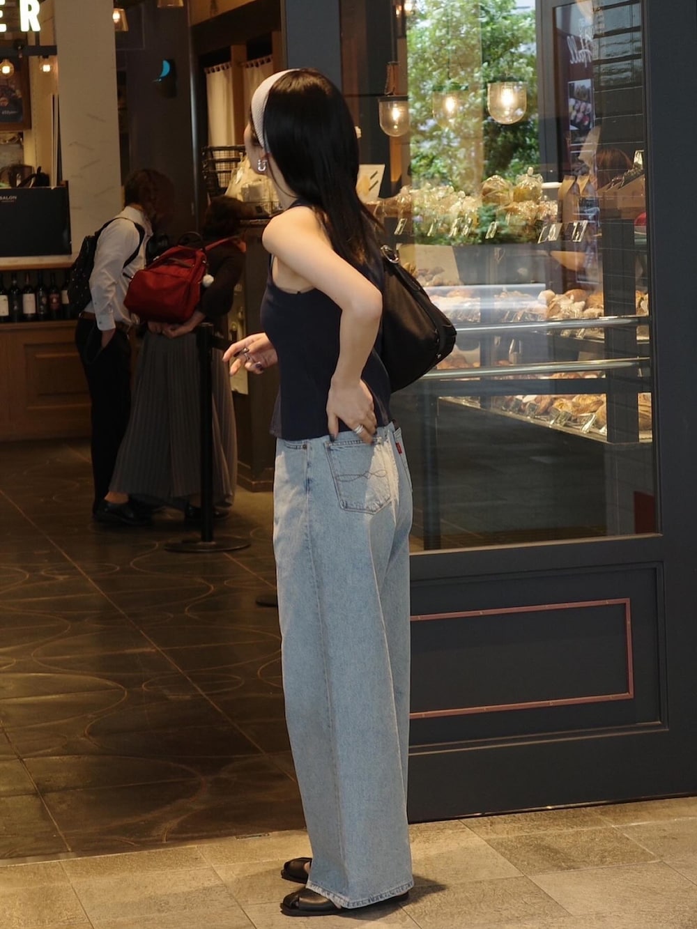 ブルー系のタンクトップ、ブルー系のデニムパンツ、ブラック系のサンダルを着用したレディースの春コーディネートの3枚目の写真