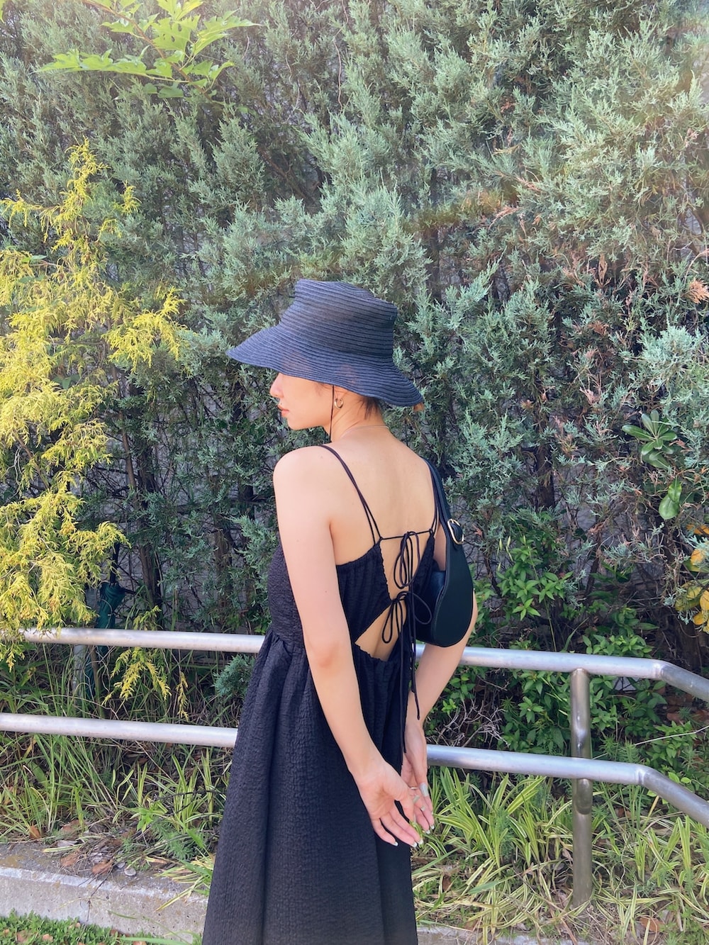 ブラック系のワンピース、ブラック系のサンダル、ブラック系のハットを着用したレディースの春コーディネートの9枚目の写真