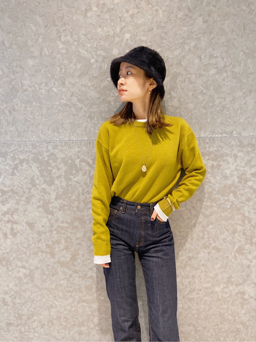 ブルー系のデニムパンツ、グリーン系のニット/セーターを着用したレディースの秋コーディネートの3枚目の写真