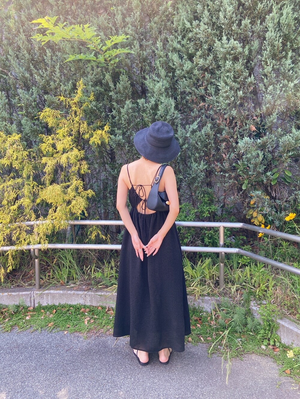 ブラック系のワンピース、ブラック系のサンダル、ブラック系のハットを着用したレディースの春コーディネートの8枚目の写真