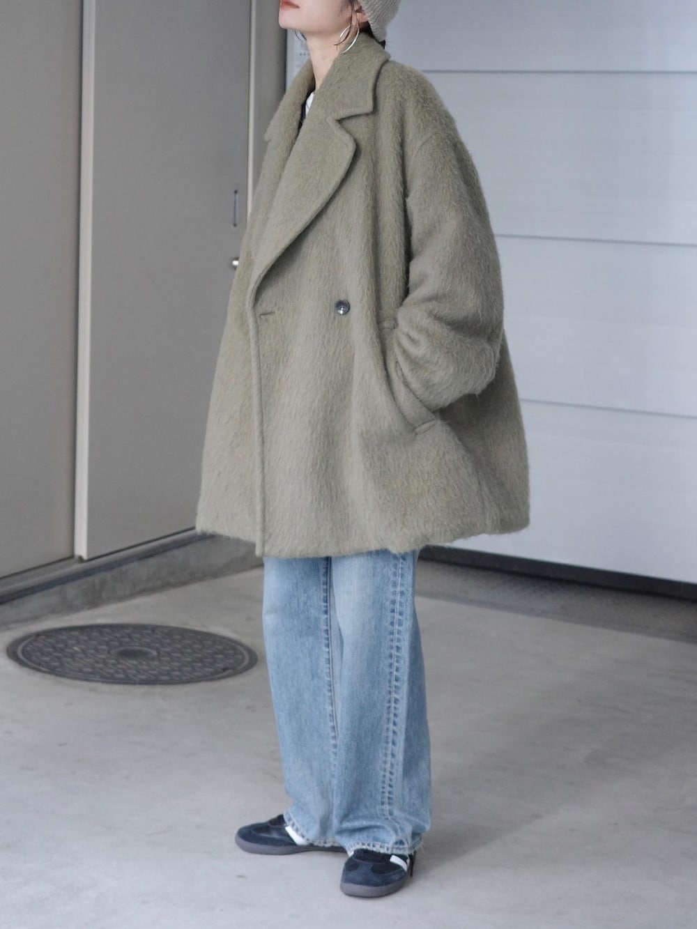 ブルー系のデニムパンツ、グレー系のニット/セーター、ホワイト系のTシャツ/カットソーを着用したレディースの冬コーディネートの2枚目の写真