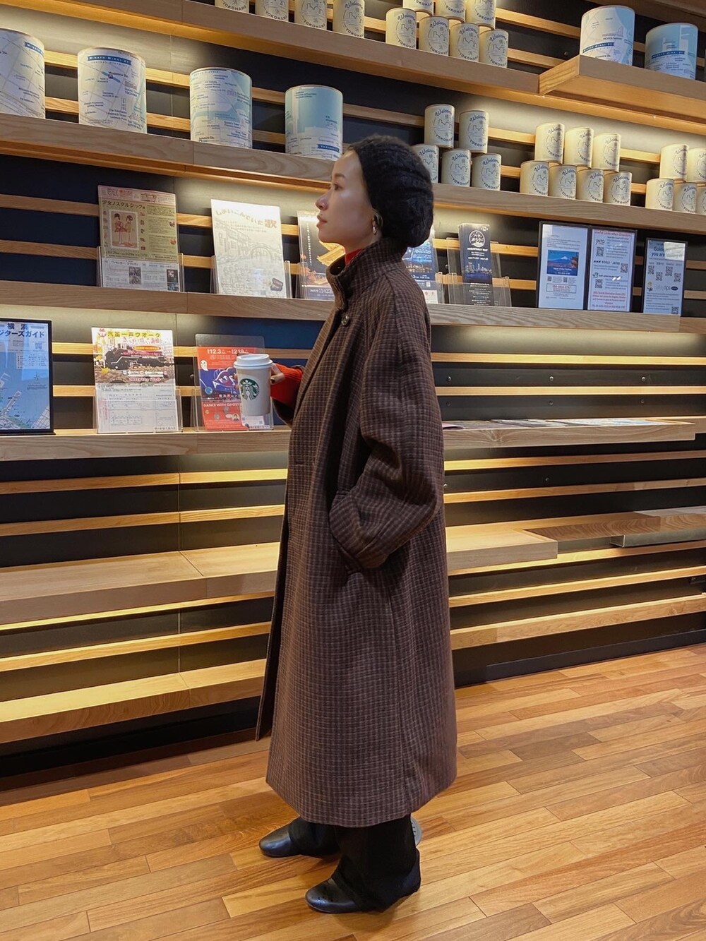 レッド系のニット/セーター、ブラウン系のその他アウター、ブラック系のデニムパンツを着用したレディースの秋コーディネートの5枚目の写真