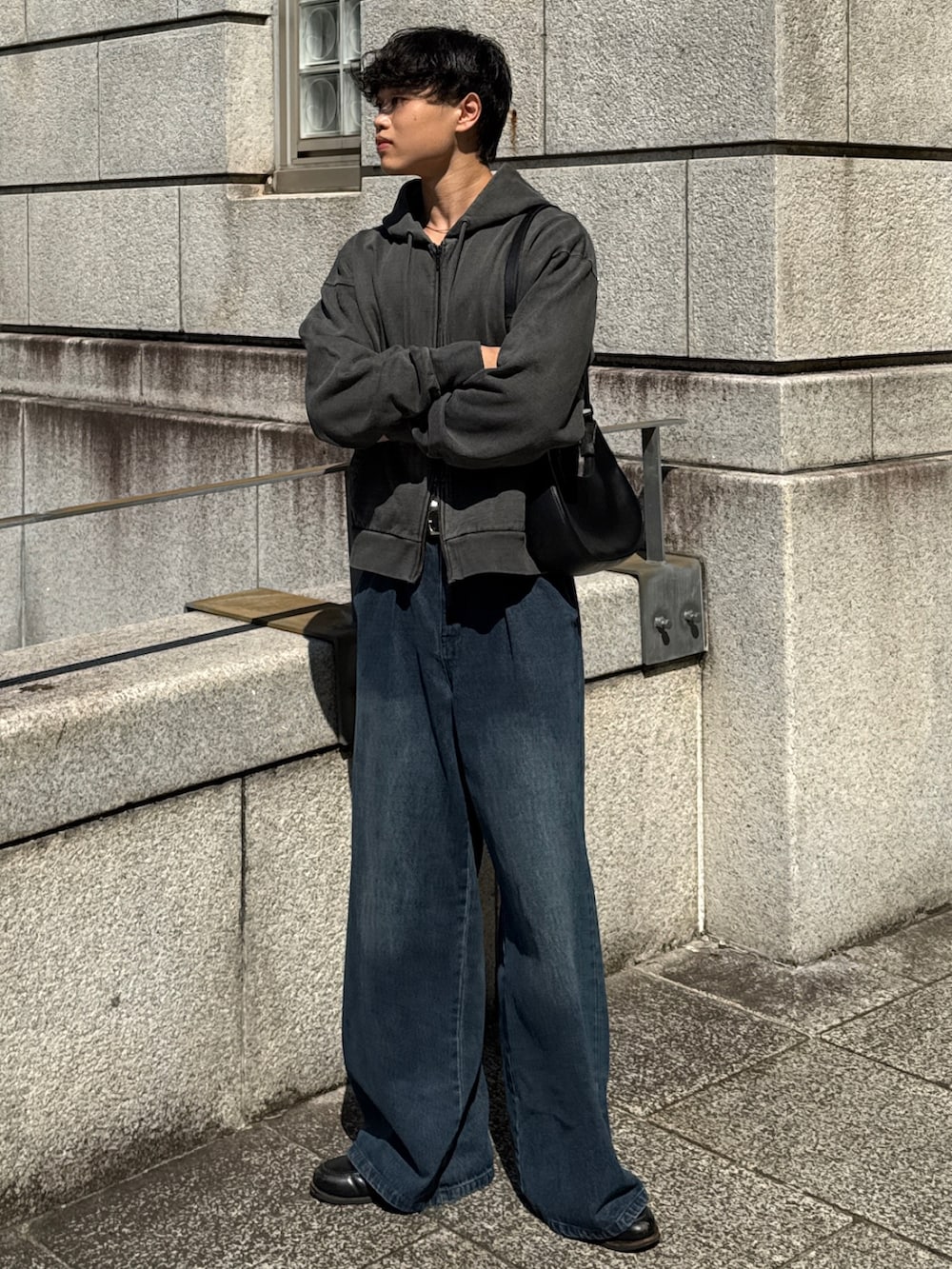 グレー系のパーカー、ブルー系のデニムパンツ、ブラック系のローファーを着用したメンズの秋コーディネートの3枚目の写真